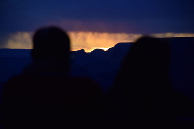 Silhouette man standing on mountain against sky during sunset