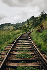 Railroad track on mountain against sky