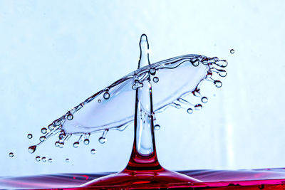 Close-up of water drop on glass against blue background