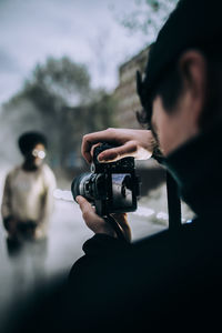 Man photographing camera against sky