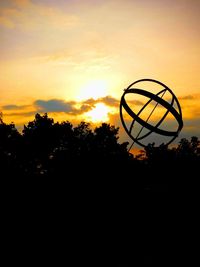 Silhouette basketball hoop against sky during sunset