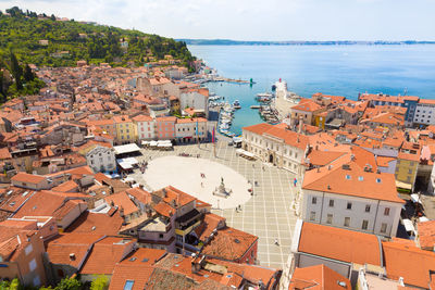 High angle view of townscape by sea against sky