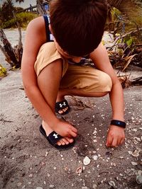 High angle view of boy sitting on land