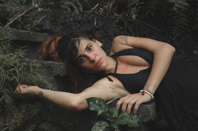 Portrait of woman lying down on plant