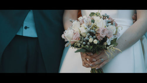 Low section of woman holding bouquet
