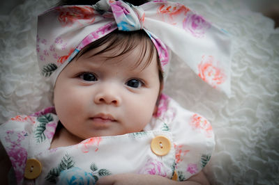 High angle portrait of cute baby lying on bed