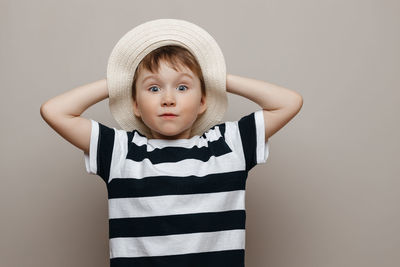 Portrait of cute girl standing against gray background