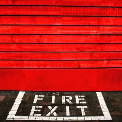 High angle view of fire exit sign by red door