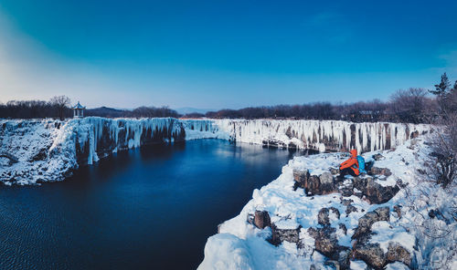 Scenic view of frozen lake against blue sky