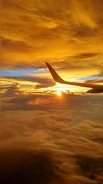 Airplane flying over sea during sunset