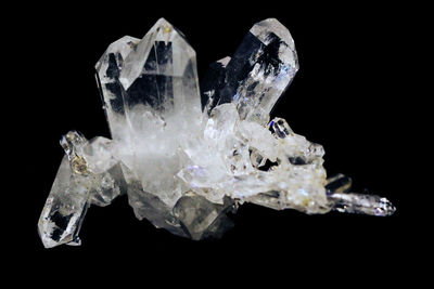 Close-up of ice crystals on rock against black background