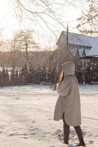 A girl in warm winter clothes walks in nature in the snow. mindfulness concept