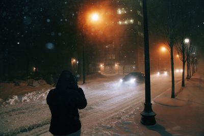 Rear view of woman on snow covered landscape at night