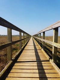 View of footbridge against clear blue sky