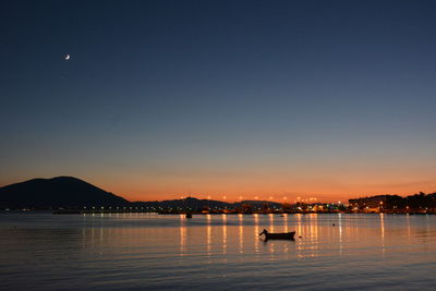 Scenic view of lake against clear sky during sunset