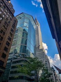 Low angle view of modern buildings against blue sky