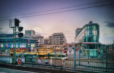 Train on railroad tracks in city against sky