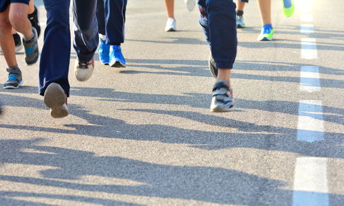 Low section of people walking on zebra crossing