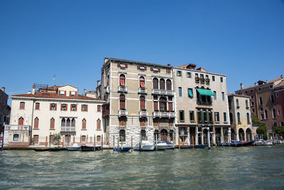 View of buildings in city against clear blue sky