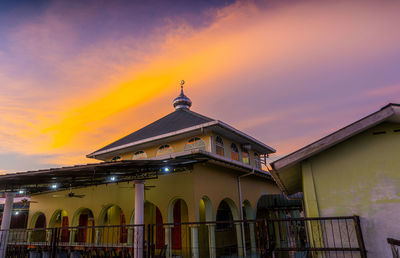 Low angle view of traditional building against sky during sunset