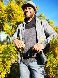 Portrait of smiling man standing against plants