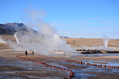 People at hot spring against mountain