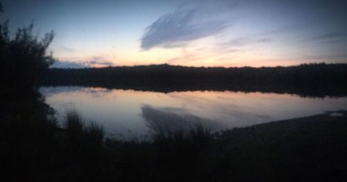 Scenic view of lake against sky at sunset