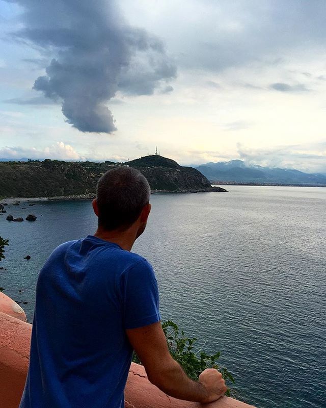 water, sky, rear view, lifestyles, cloud - sky, leisure activity, casual clothing, sitting, sea, people, cloud, standing, waist up, looking at view, nature, lake, beauty in nature, tranquility