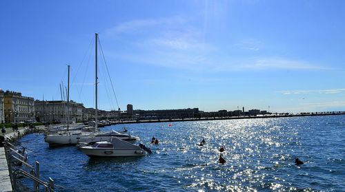 Boats in sea against blue sky