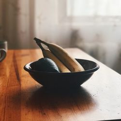 Close-up of bananas and avocado in bowl on table