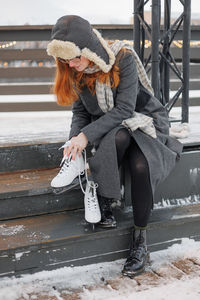 Portrait of young woman sitting on snow
