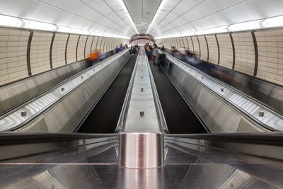 Blurred motion of people on escalators in subway station