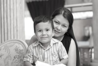 Portrait of mother with son sitting at home