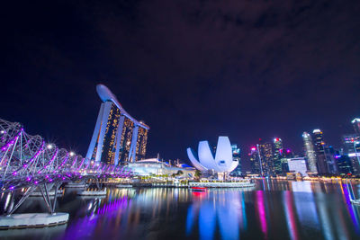 Illuminated city buildings against sky at night