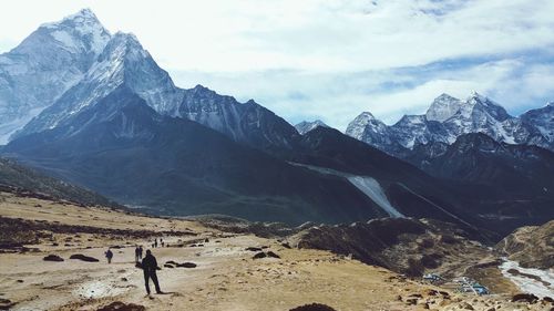 Rear view of person on snowcapped mountains against sky