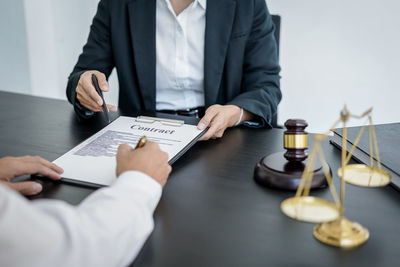 Midsection of lawyer working at desk in office