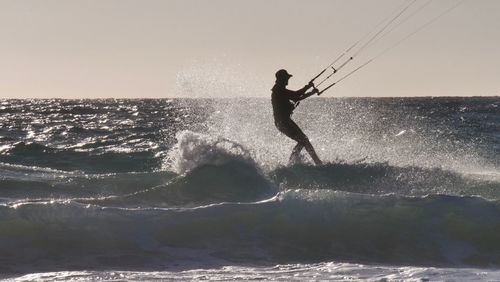 Man surfing in sea against sky