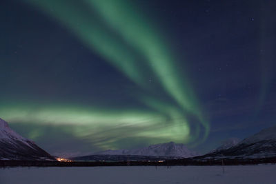 Aurora borealis over snowcapped mountains at night