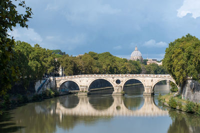 Arch bridge over river against sky