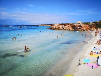 People enjoying at beach against sky