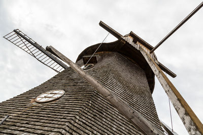 Low angle view of traditional windmill against sky