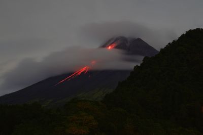 Yogyakarta, indonesia, feb 27, 2022. incandescent lava flows out at night from peak of mount merapi. 
