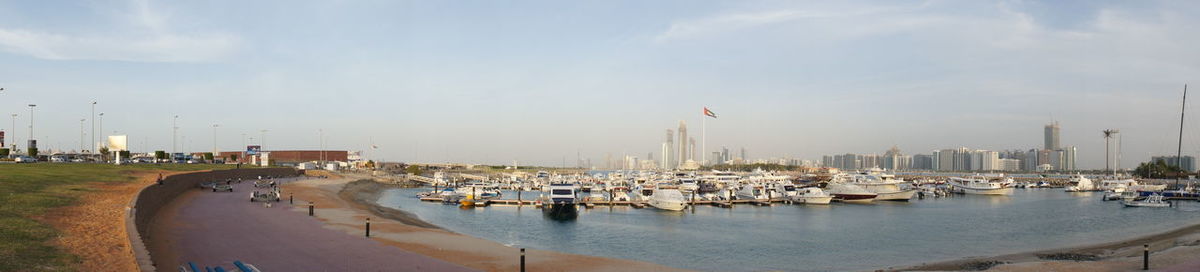 Panoramic view of harbor by buildings against sky