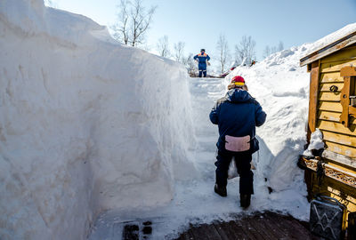 Rear view of people standing on snowcapped mountain