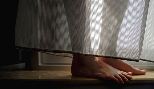 Close-up of woman lying on wall