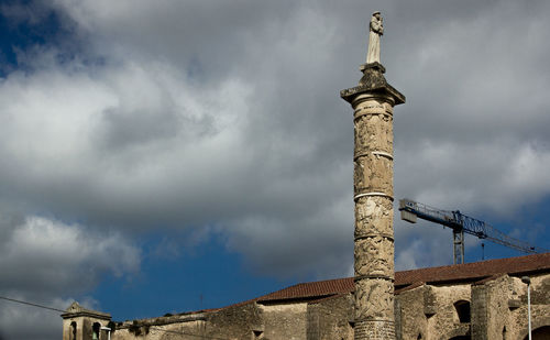 Low angle view of tower against cloudy sky