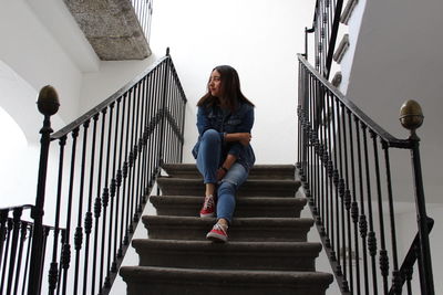 Low angle view of woman sitting on stairs