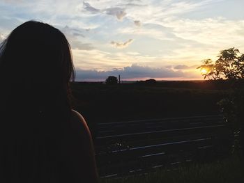 Rear view of woman at sunset
