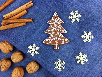 High angle view of gingerbread cookies with lemon and walnuts by cinnamon on table