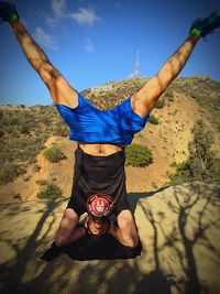 Man performing headstand against hollywood sign